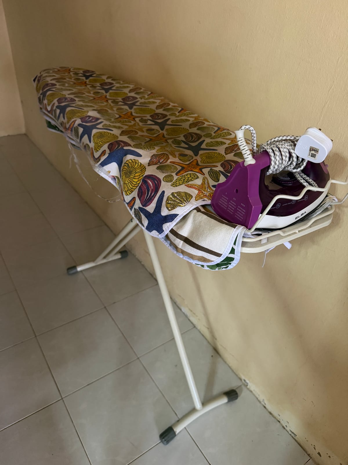 Seterika di atas papan seterika untuk kegunaan tetamu