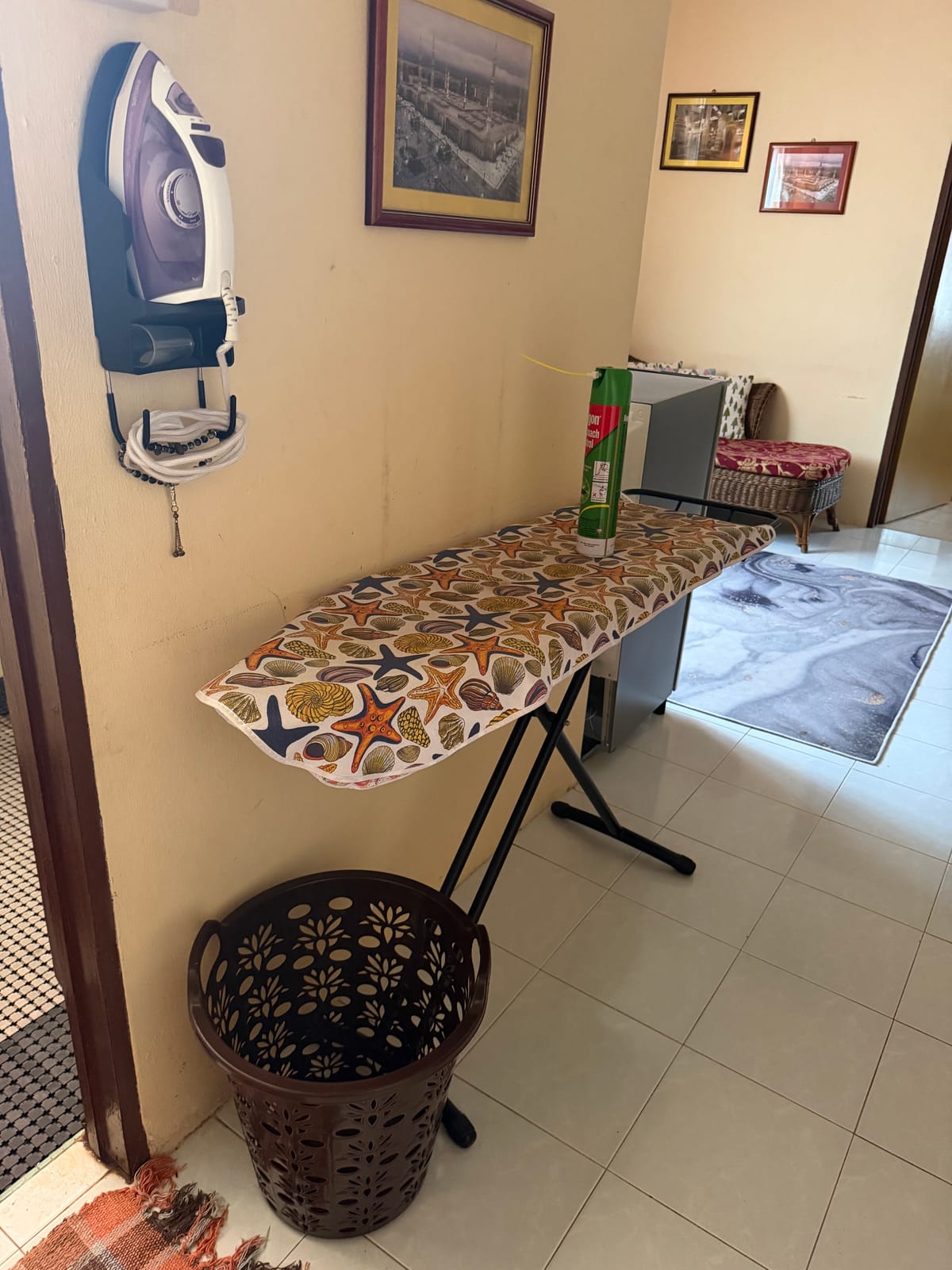 Papan seterika dan seterika yang disimpan pada dinding