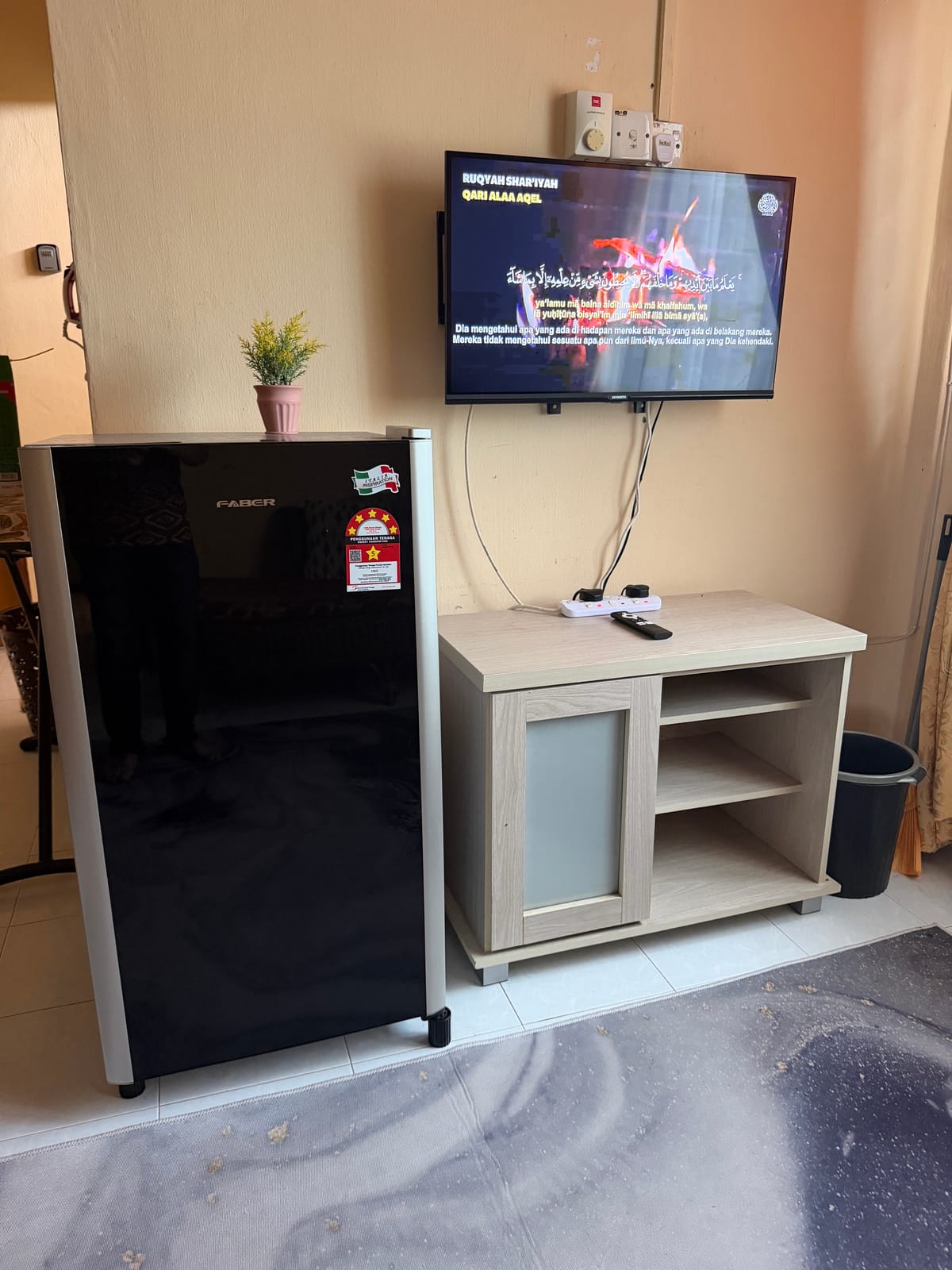 TV pada dinding, kabinet dan peti sejuk di ruang rumah